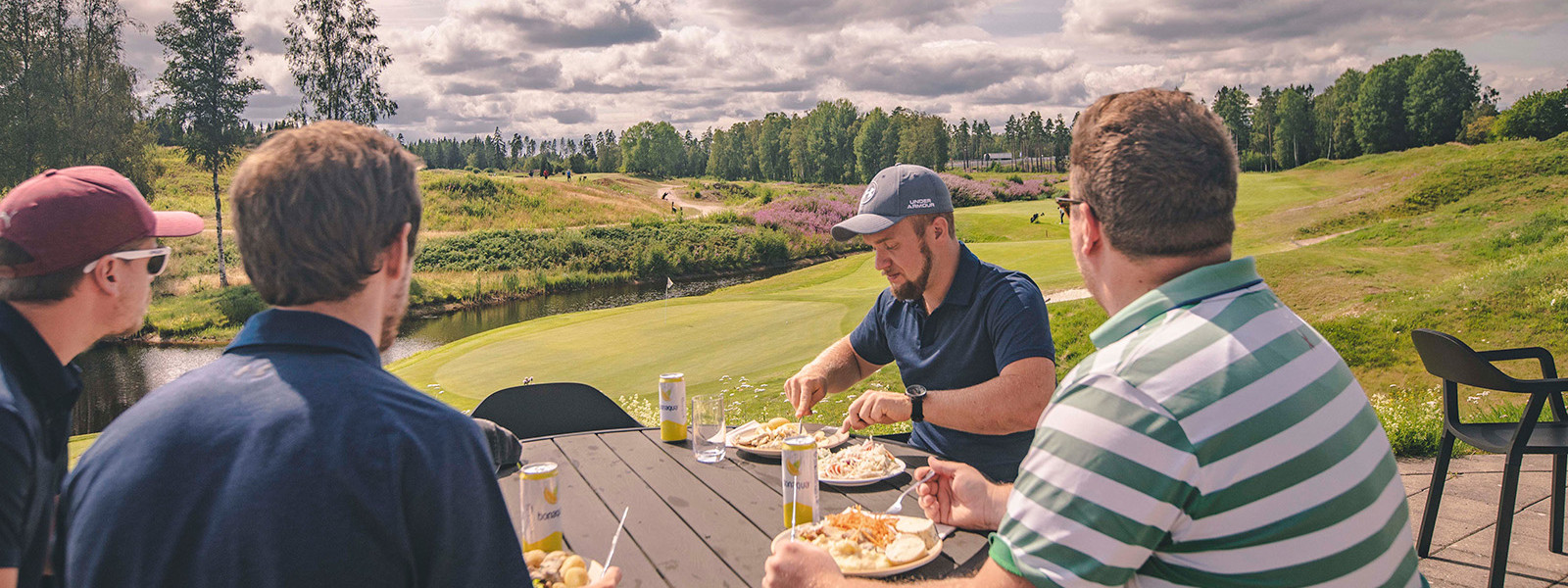 Fyra män äter på uteserveringen på sand